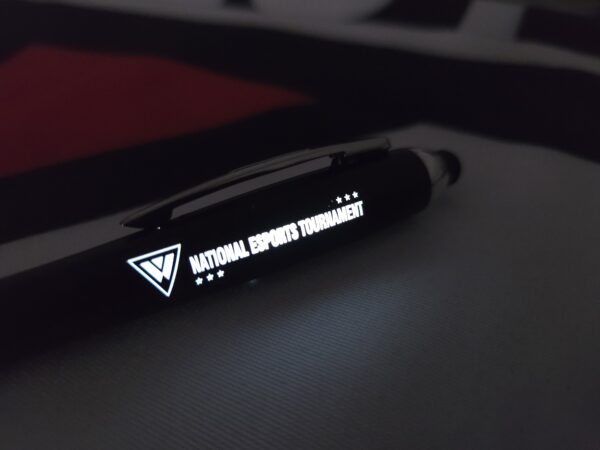 The same pen shown in a dark environment, with the NEST logo brightly illuminated in white LED light